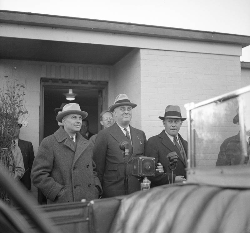 Photograph of a group of men surrounding President Franklin Roosevelt giving a speech.