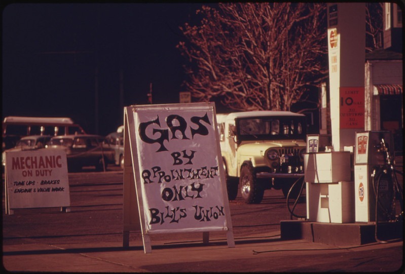 Photograph of a gas station with a sandwich board sign that reads "Gas by Appointment Only"