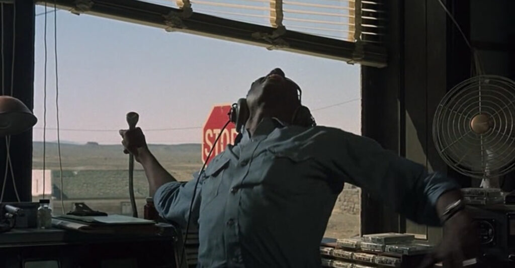 Blind radio DJ Super Soul yelling to the sky with a prominent stop sign visible in the window behind him.
