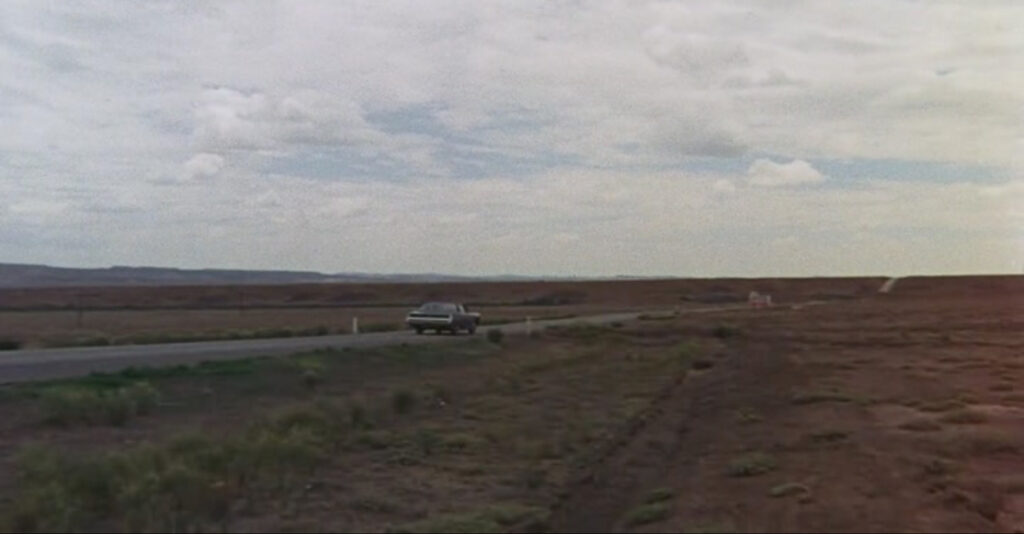 Film still of the camera now following the black Ford LTE in the opposite direction of Kowalski's path.
